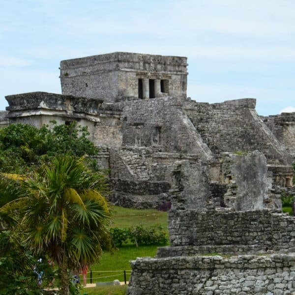 Explore the ancient Mayan ruins of Tulum near Cancún, surrounded by lush greenery and historic structures.