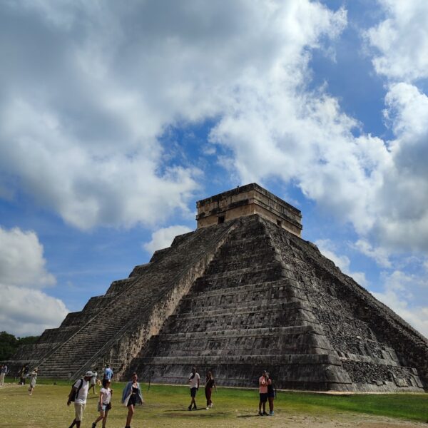 a group of people standing in front of a pyramid